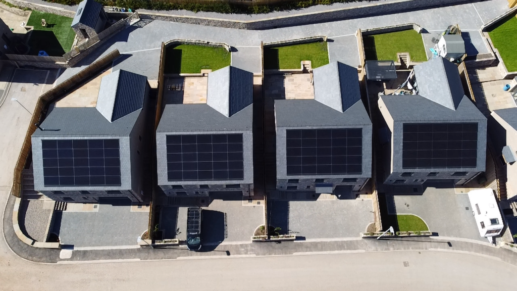 Aerial view of houses with solar panels on roofs.