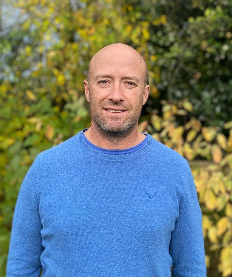Man in blue jumper outdoors
