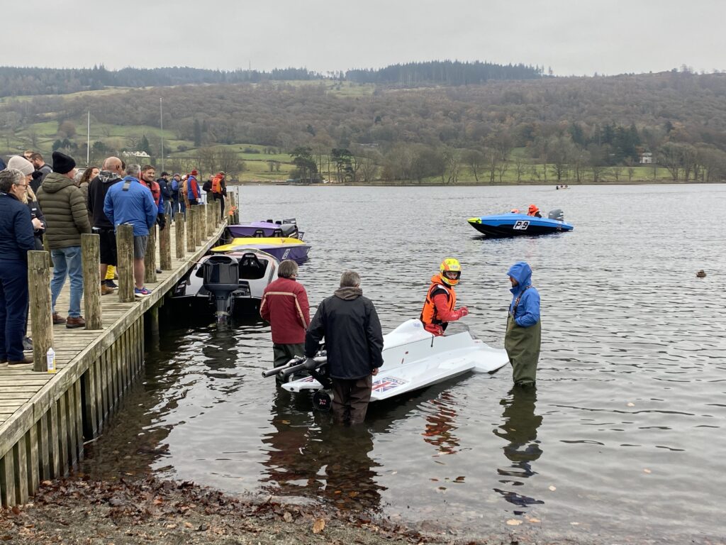 People at dock with powerboats on lake.
