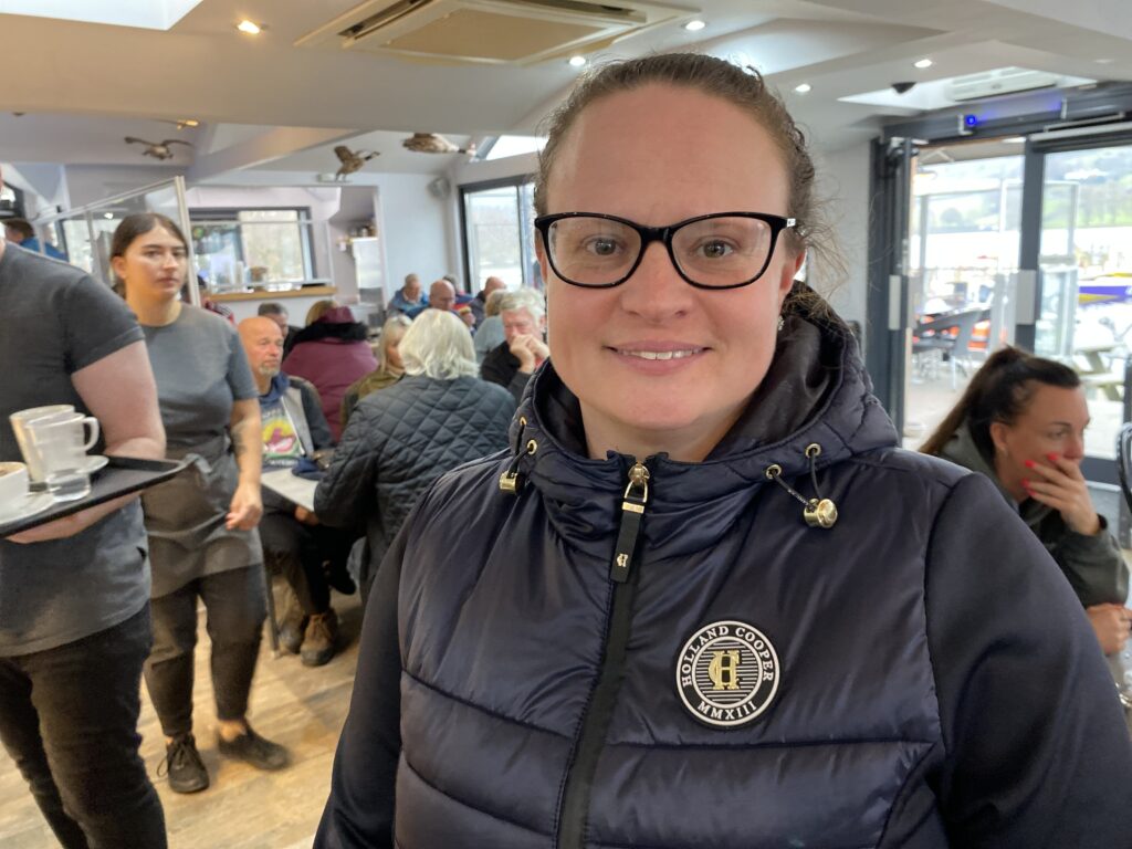 Smiling woman in a busy café interior.