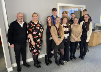 Group of professionals posing in office setting.
