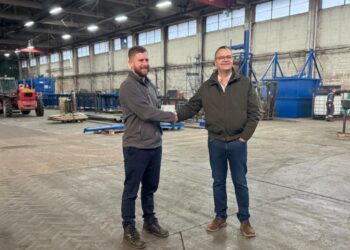 Two men shaking hands in warehouse