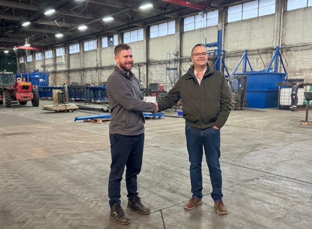 Two men shaking hands in warehouse