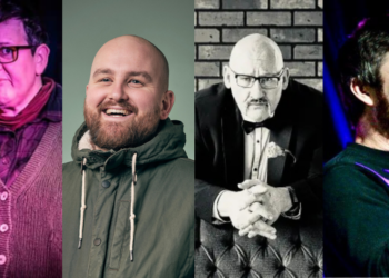 Four comedians performing on stage with microphones.