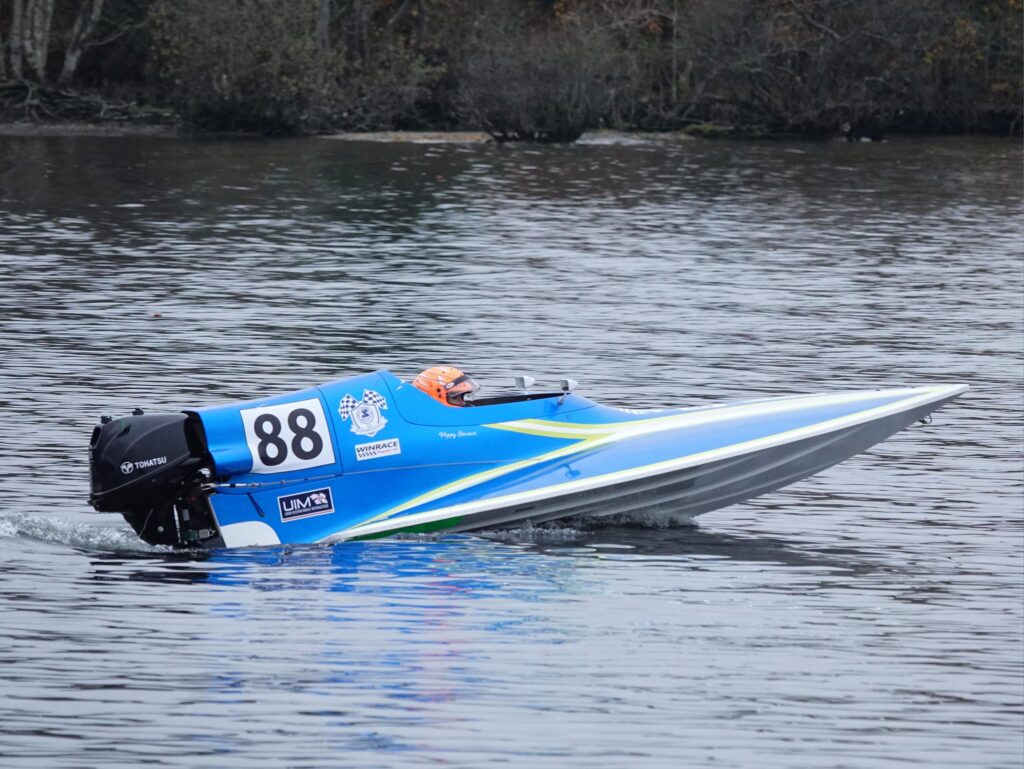 Speedboat racing on a calm lake, number 88 displayed.